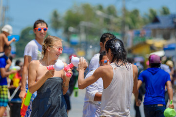 Thais and tourists shooting water guns, pour water on each other, having fun at Songkran festival, the traditional Thai New Year