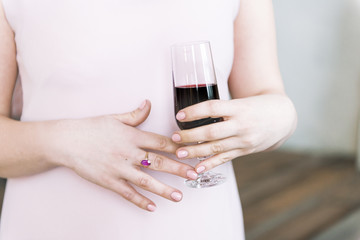 hands of a woman holding glass of wine