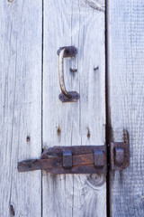rusty metal latch on wooden door