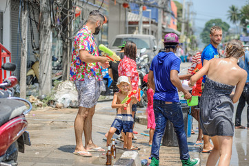 Obraz na płótnie Canvas Thais and tourists shooting water guns, pour water on each other, having fun at Songkran festival, the traditional Thai New Year