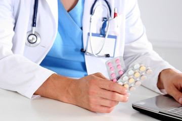 Hand of doctors holding many different pills