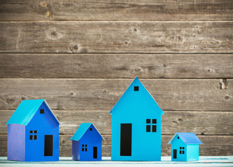 A paper houses stands over a wooden background