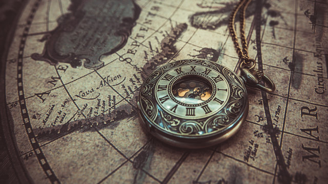 Antique necklace pendant watch on the ancient world map.