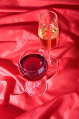 Two Glass of red, white wine on red background