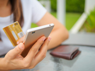 Online payment, women's hands holding a credit card and using smart phone for online shopping