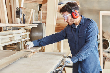 Schreiner schleift Holz an Bandschleifmaschine