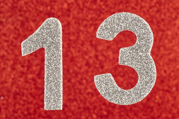 Number thirteen silver color over a red background. Anniversary.