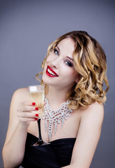 Portrait d'une jeune femme souriante, de face, tenant une flûte de champagne