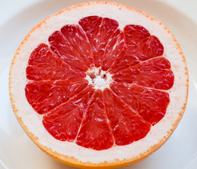 Half of a pink grapefruit on the plate.