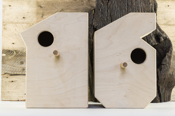 Wooden bird houses in shaped of numbers on a old rustic wooden planks background