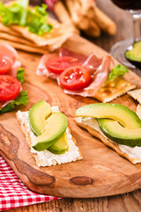 Crackers with ham and avocado. 