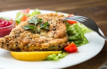 closeup of Homemade Breaded Schnitzel with salad and berry sauce