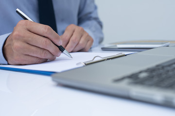 Fototapeta premium Businessman writing on note pad