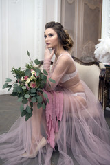 bride's morning. Young girl posing in pink sheer nightie