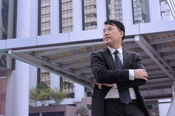 Confident Asian Businessman standing and looking at city for vision concept