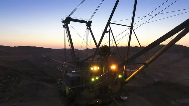 Boom of a walking excavator. Panorama. Sunset. Mine. View from the drone.