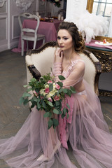 bride's morning. Young girl posing in pink sheer nightie