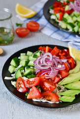 Vegetable salad with avocado and mustard sauce on a concrete, gray background