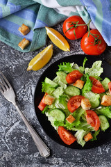 Vegetable salad with cucumber, tomatoes and olive oil on a concrete background