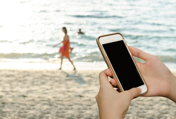 woman using mobile smartphone at beach
