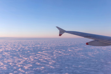 Aircraft wing over clouds, flying background clouds over USA