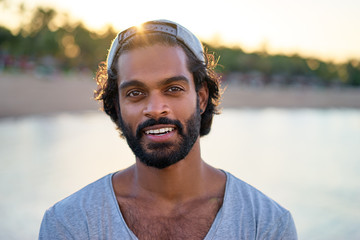 Handsome and confident. Outdoor portrait of smiling young african man on the beach.