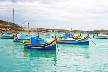 Fototapeta na wymiar Luzzu colorful boats at Marsaxlokk Harbor of Malta