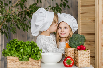 Kids in the kitchen making vegetable salads. Healthy food. Vegetables. Family