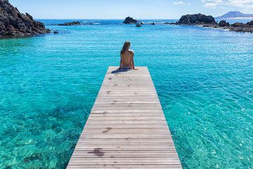 Espagne, Canaries, Fuerteventura, Isla de lobos. Fille seins nus sur une jetée eau transparente claire