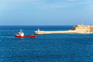 Fototapeta premium Dry cargo carrier and Breakwater at Fort Ricasoli of Kalkara