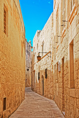 Narrow silent street with lamp in Mdina
