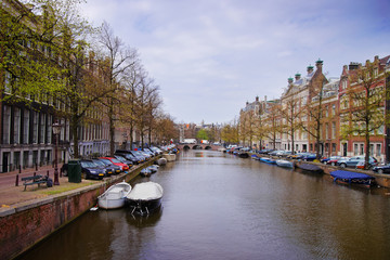 Boats on canal of Amstel River and buildings Amsterdam