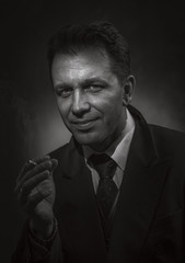 Black and white portrait of a smiling smoking man.