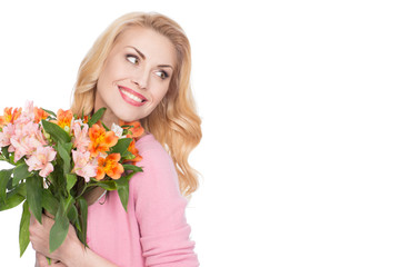 Obraz na płótnie Canvas Joyful soul. Gorgeous cheerful mature woman holding bunch of flowers looking over the shoulder smiling happily isolated on white