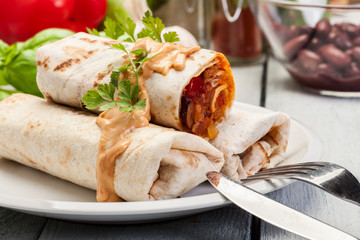 Mexican burritos wraps with mincemeat, beans and vegetables