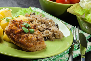 Fried pork schnitzel served with boiled potatoes and fried sauer