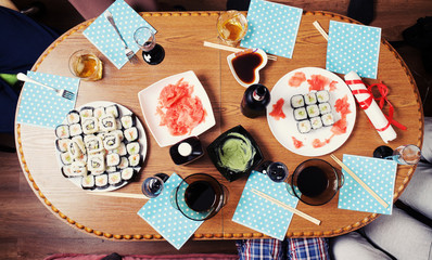 table with sushi set and wine with glasses