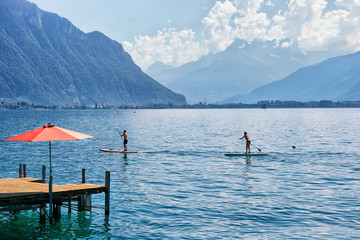 Fototapeta na wymiar Couple with Standup paddle board on Geneva Lake Montreux