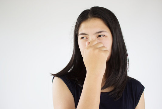Woman pinches nose with fingers hands from smelling of something