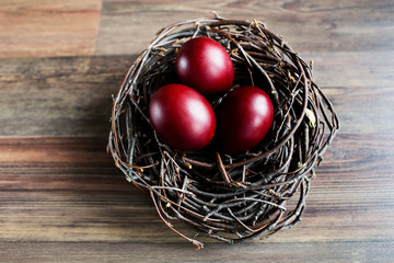 Easter eggs in the nest on wooden background