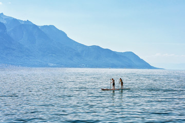 Couple with Standup paddle surfing board on Geneva Lake Montreux
