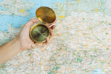 Woman hand holding big gold vintage compass. Thirst for wanderings. Help choose a direction. 