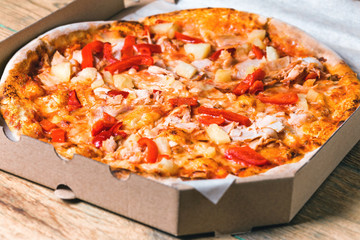 Pizza in box on wooden table