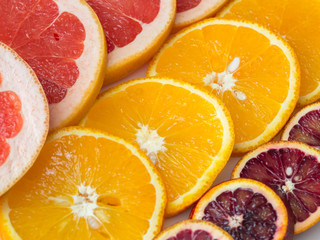 Obraz na płótnie Canvas Citrus fruit background with sliced oranges , sicilian oranges grapefruit as a symbol of healthy eating and immune system boost with natural vitamins.