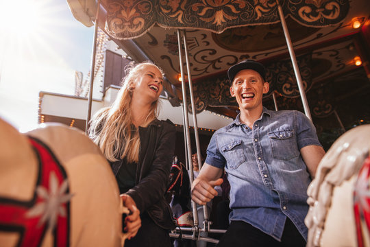 Smiling friends on amusement park carouse
