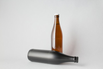 The composition of two bottles: one stands and the other is tipped over