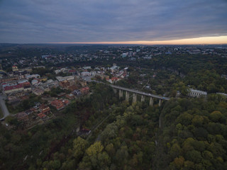 Aerial shot of the canyon of the Smotrych River towards the Novoplanivskyi Bridge in Kamianets-Podilski Ukraine. The shot is taken in autumn with the canyon trees looking colourful