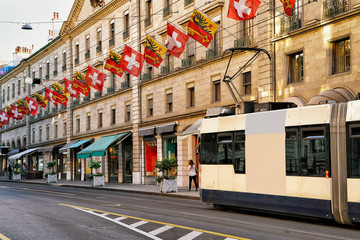 Tram in Rue Corraterie Street with Swiss flags in Geneva