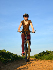 Fototapeta na wymiar Girl riding a bike on a dirt road.
