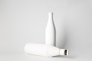 The composition of two bottles: one stands and the other is tipped over